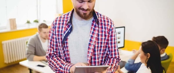 Happy young male executive using tablet computer at creative office 600x254