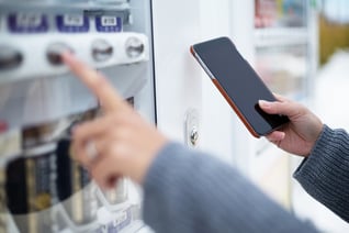 Woman use of soft drink vending system paying by cellphone